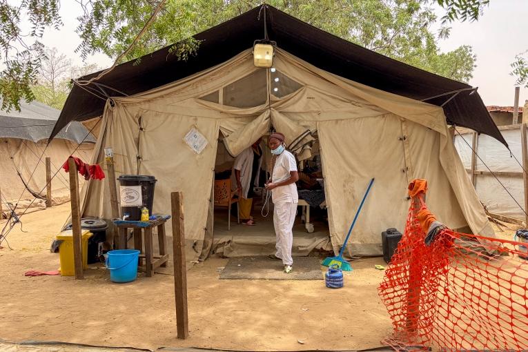 Un membre du personnel de MSF se tient devant une tente d'isolement pédiatrique, où les enfants atteints de rougeole reçoivent des soins intensifs. Hôpital d'Adré, province de Ouaddaï, Tchad.