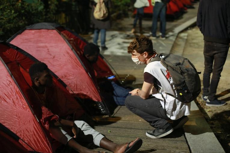 Un travailleur social MSF discute avec un mineur isolé étranger lors de l'installation du camp à Paris, près de la place de la République. 2020.