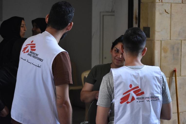 Des membres des équipes MSF en discussion avec une personne déplacée installée dans le refuge d'Azarieh à Beyrouth, lors d'une clinique mobile. Octobre 2024. Liban. 