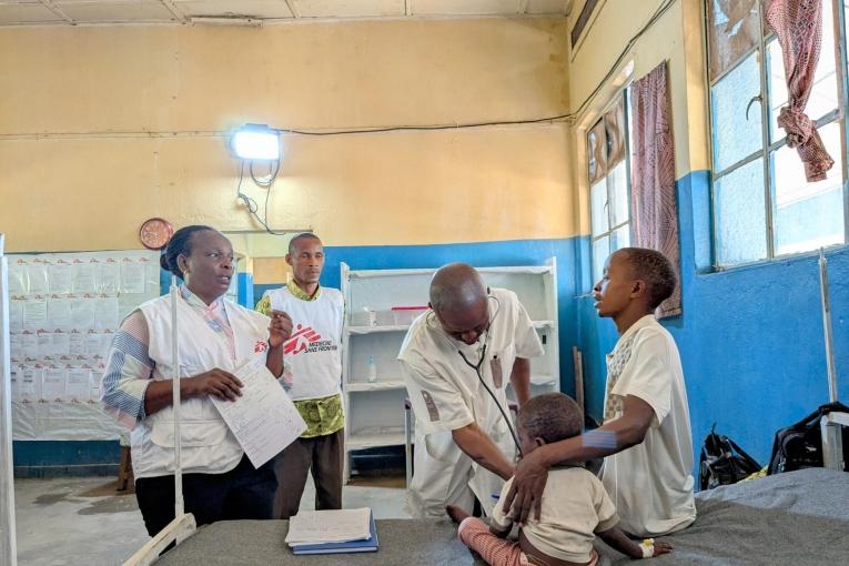 Un médecin et l'équipe de MSF  examinent un enfant de trois ans hospitalisé depuis deux jours pour une rougeole dans un hôpital du Sud Ubangi