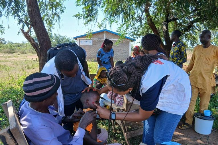 Le médecin référent de l'équipe EURECA examine l'état de santé d'un enfant lors d'une intervention d'urgence dans la région de Kabo.