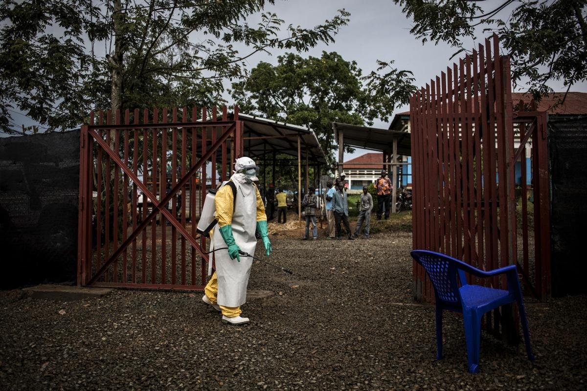 Un travailleur de santé MSF désinfecte l'entrée du centre d'isolement de Bunia après l'admission d'un patient affecté par Ebola. 2018. République démocratique du Congo. 
 © John Wessels