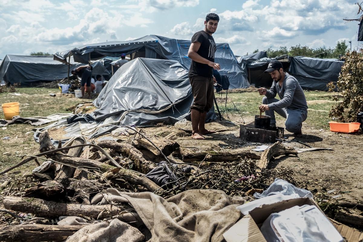 Deux hommes originaires de Syrie cuisinent avec des matériaux de récupération dans un camp informel près de Velika Kladuša. Bosnie-Herzégovine. 2018.
© Kamila Stepien