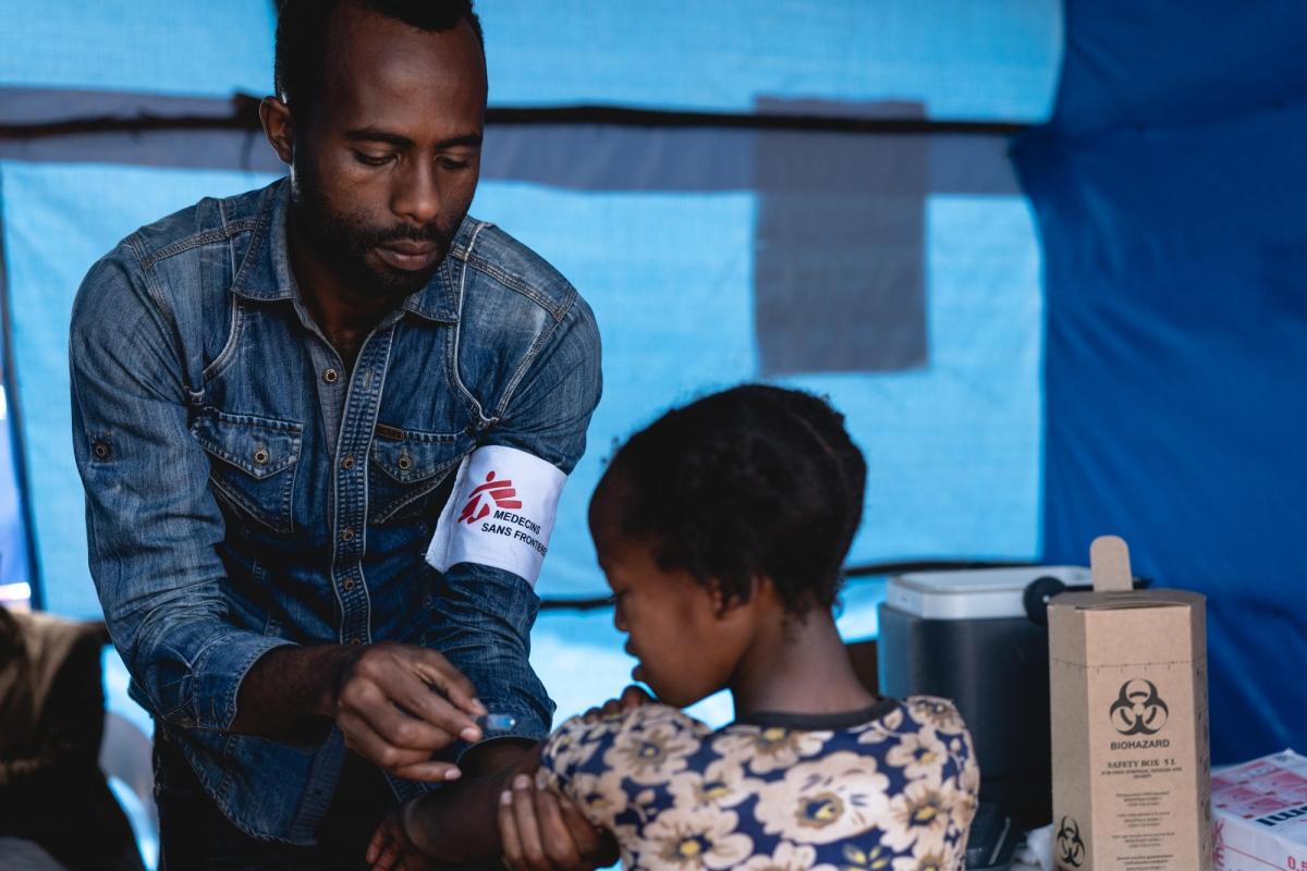Un volontaire MSF vaccine un enfant contre la rougeole dans le cadre d'une campagne de vaccination de masse organisée par les autorités éthiopiennes. Éthiopie. 2018.
 © Gabriele François Casini/MSF