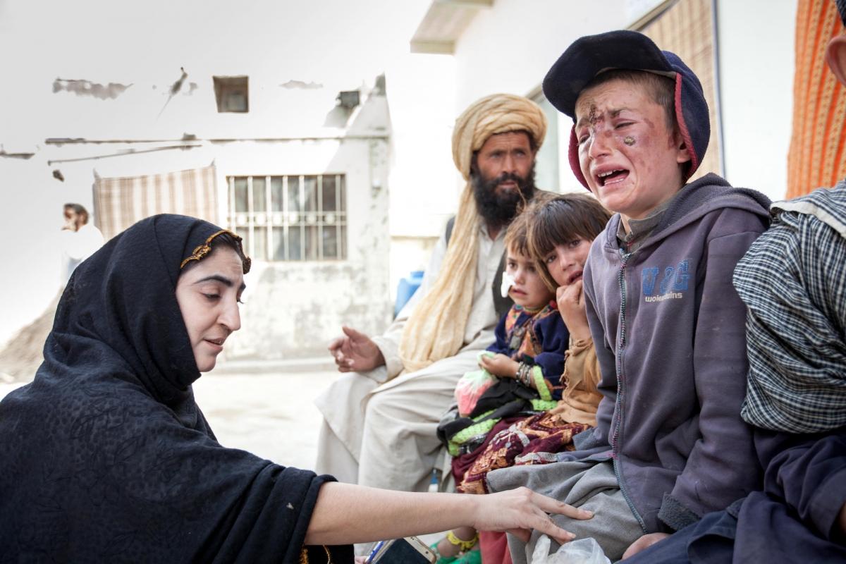 Une conseillère MSF rassure un jeune garçon avant qu'il reçoive son traitement contre la leishmaniose cutanée dans la clinique de Kuchlak. Pakistan. 2018. 
 © Khaula Jamil