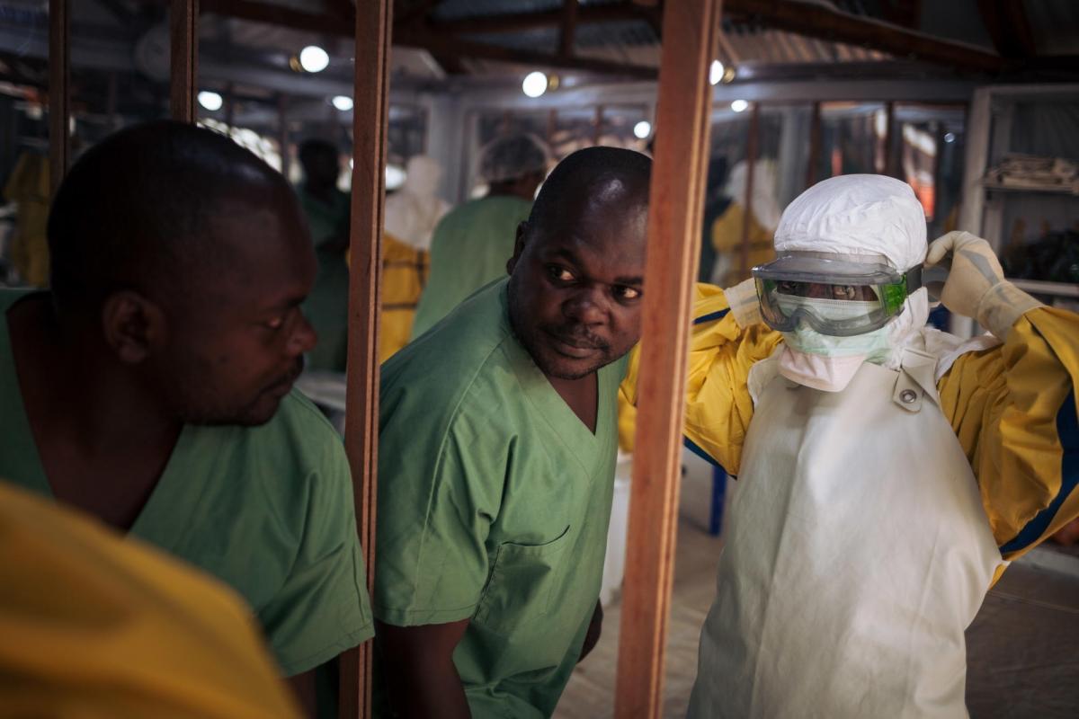 Un travailleur de santé revêt son masque avant d'entrer dans la zone à risque d'un centre de traitement Ebola. Novembre 2018. République démocratique du Congo. 
 © Alexis Huguet
