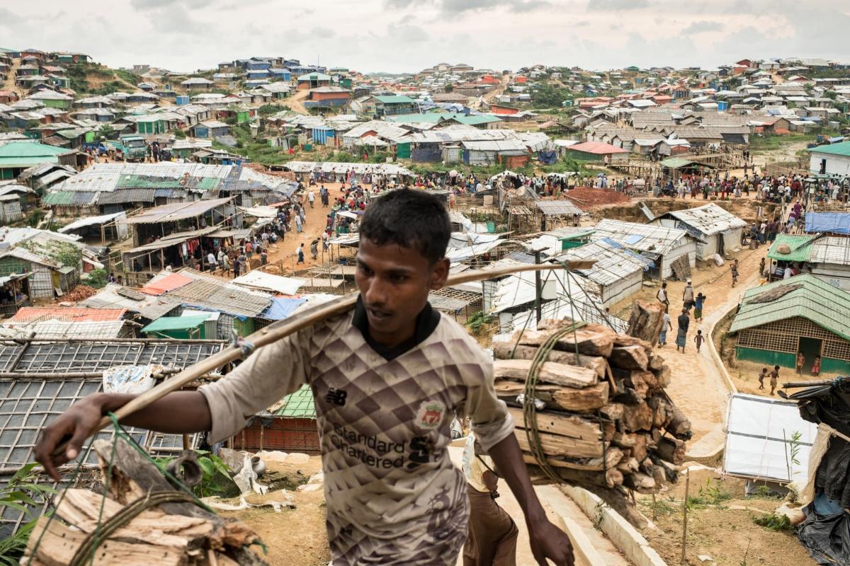 Un homme transporte du bois dans l'un des camps de réfugiés du district de Cox’s Bazar, au Bangladesh.
 © Robin Hammond/NOOR