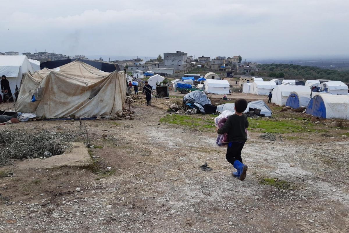 Un enfant retourne dans sa tente, portant des couvertures qu'il a reçues lors d'une distribution MSF. Le camp où lui et sa famille se sont installés, dans la région de Jebel Harem, accueille environ 120 familles. 
 © MSF