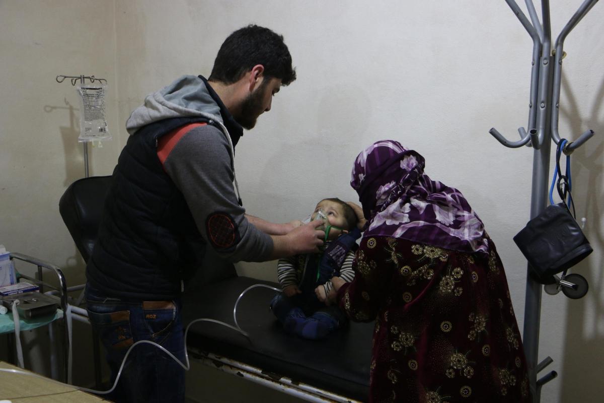 Un jeune enfant, accompagné par sa mère, se fait ausculter dans le centre de santé du camp de Deir Hassan. 
 © Abdul Majeed Al Qareh