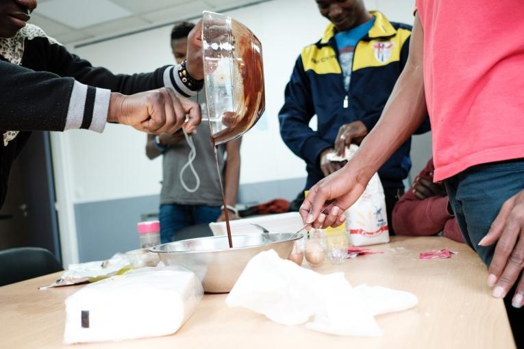 Des jeunes participent à un atelier cuisine et pâtisserie avec un membre de l’équipe de MSF du projet Passerelle.
© Augustin Le Gall