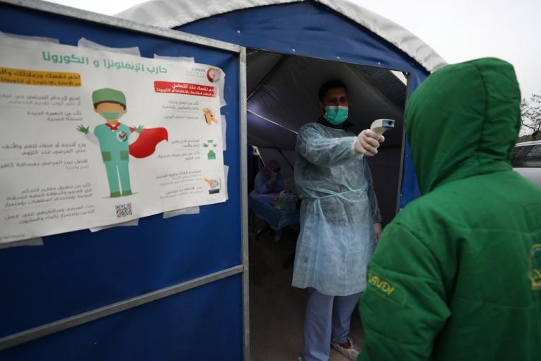 Un médecin MSF prend la température d'un patient avant qu'il entre dans un centre MSF dédié à la gestion de la Covid-19. Syrie. 2020. 
 © MSF
