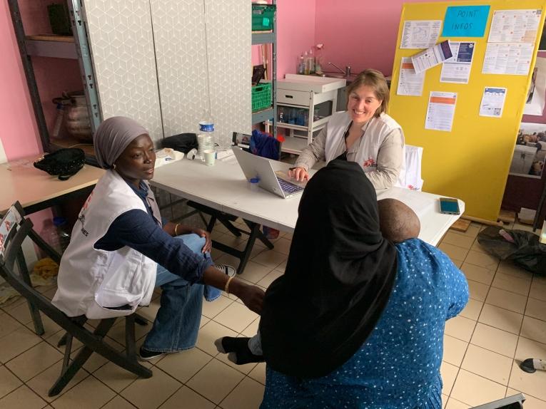 Une femme exilée et son enfant en consultation avec une infirmière MSF et une médiatrice culturelle MSF, à l'accueil de jour du Secours Catholique à Calais. France. Juin 2025.
 © Méryl Sotty / MSF