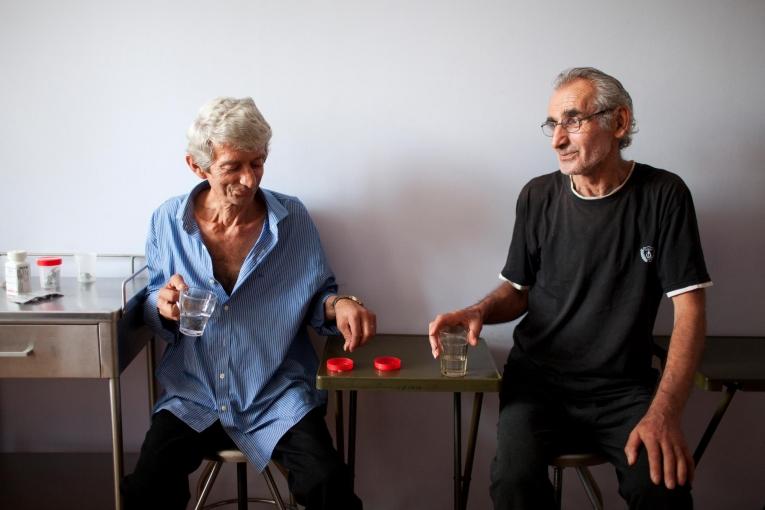 Les patients Akhmed Khojava (gauche) et Nugzar Papashvili (droite) prennent leur « traitement sous surveillance directe », comme tous les patients du centre national de traitement de la tuberculose et des maladies pulmonaires de la capitale géorgienne, Tbilissi.
 © Daro Sulakauri/MSF
