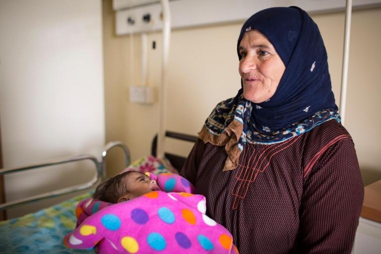 La famille du petit Mohamed, dans les bras de sa grand-mère, devait emprunter de l’argent auprès de ses proches pour pouvoir payer chaque visite à l’hôpital, jusqu’au jour où on leur a parlé d’un service de pédiatrie géré par MSF qui fournissait des services de santé gratuits.
 © Florian SERIEX/MSF