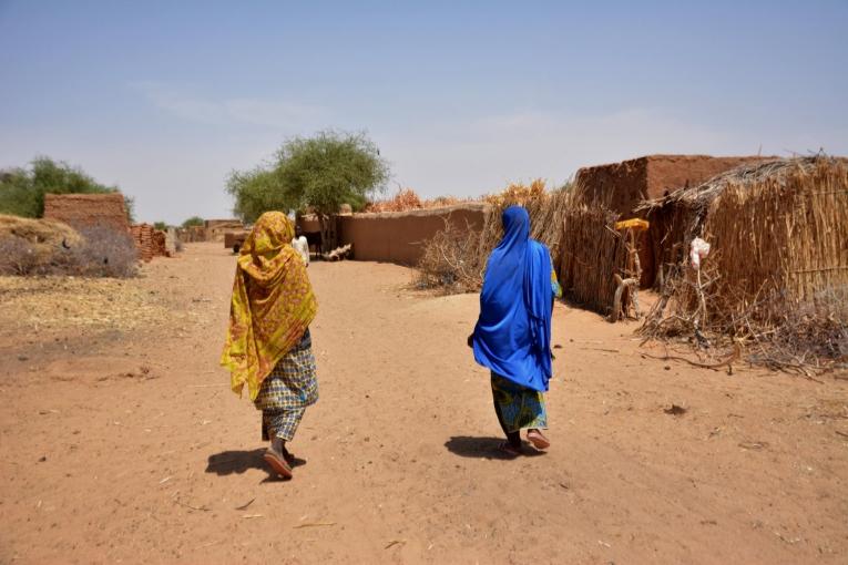 Une matrone marche dans son village avec une femme qu'elle a récemment référée aux équipes de Médecins Sans Frontières. 
 © Elise Mertens/MSF