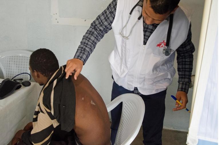 Un médecin MSF ausculte un patient dans une salle de consultation aménagée dans un foyer pour migrants dans la ville de Beni Walid. En collaboration avec une ONG locale, MSF organise des consultations dans ce foyer et des références vers d'autres hôpitaux pour les cas médicaux les plus graves. 
 © Christophe Biteau/MSF
