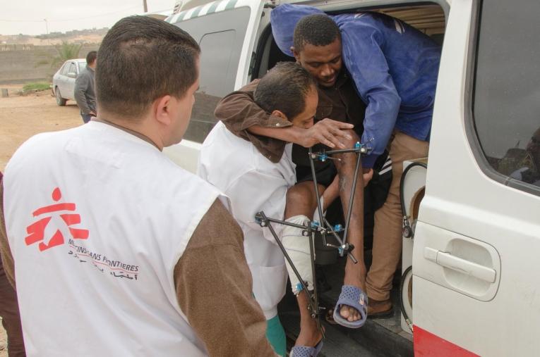 L’équipe médicale MSF réfère un patient depuis Bani Walid vers une structure de soins secondaires. Il est suivi depuis plusieurs semaines et souffre de fractures multiples aux deux jambes. La très grande majorité des patients pris en charge à Bani Walid ont réchappé de prisons clandestines présentes dans la région. Ils ont été kidnappés, torturés et retenus captifs par des réseaux criminels qui leur font vivre un calvaire pour obtenir d’eux une rançon. Ces rescapés sont profondément affaiblis, avec des plaies qui se sont infectées, et de multiples traumatismes. 
 © Christophe Biteau/MSF