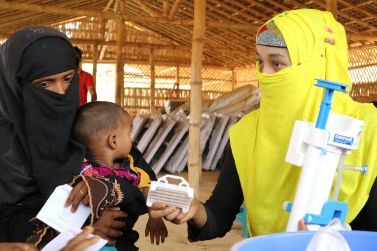 Une formatrice locale explique à une ancienne patiente MSF comment utiliser et entretenir un filtre à eau. Ces filtres sont distribués gratuitement par MSF dans le camp de Kutupalong-Balukhali.
 © MSF