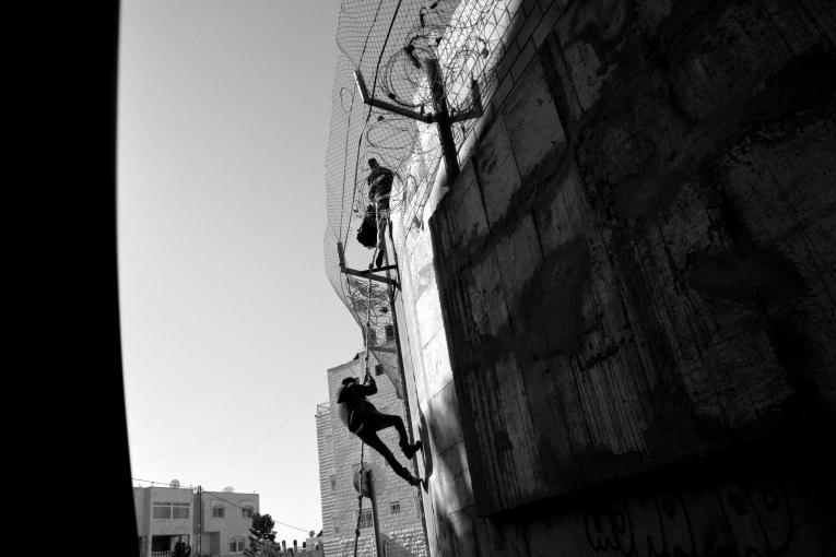 Des palestiniens rentrent à Jérusalem-Est en escaladant le mur pour éviter la longue attente au checkpoint. 2014.
 
 © Aurelie Baumel/MSF