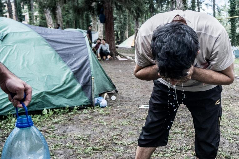 Deux personnes originaires du Kurdistan irakien se lavent les mains avant de cuisiner. Près de Bihać, ces personnes ont un accès limité à l'eau. Bosnie-Herzégovine. 2018.
© Kamila Stepien