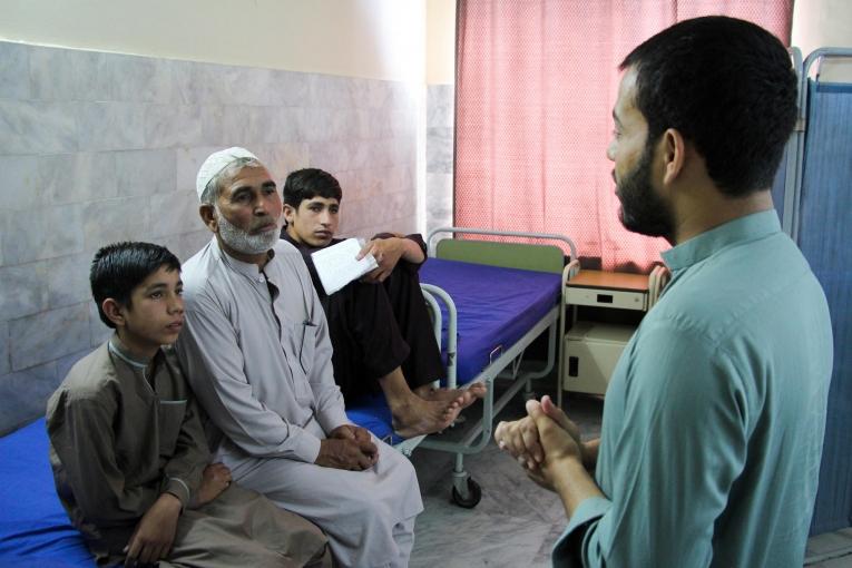 Muhammad Jannat et ses deux fils lors d'une séance de sensibilisation avec un promoteur de santé dans le centre de traitement MSF de Peshawar. 2019. Pakistan. 
 © Nasir Ghafoor/MSF