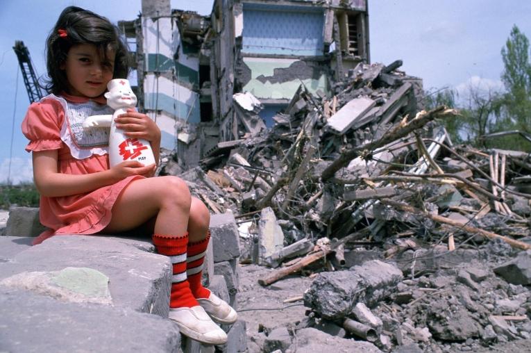 Une petite fille devant les décombres d'un bâtiment de Gyumri, à la suite du tremblement de terre de 1988.
 © Roger Job