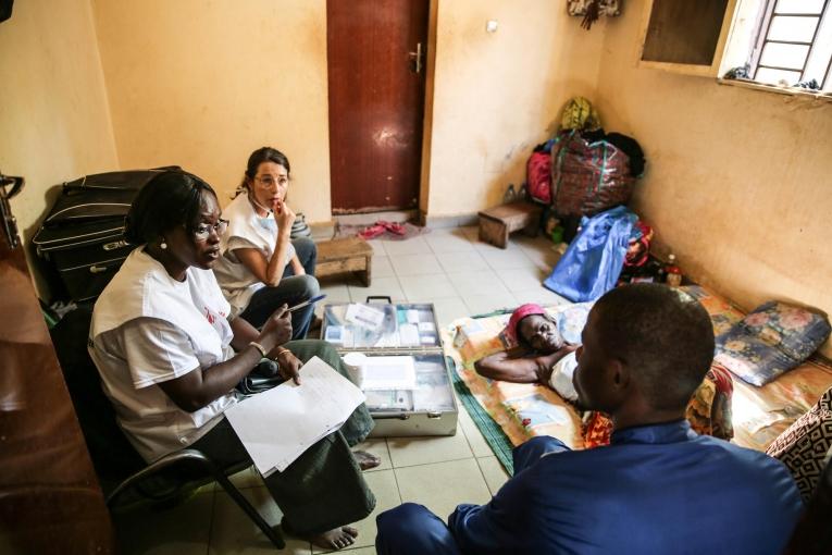 Le Dr. Djénabou Diallo et l'infirmière Nathalie Kornfein en discussion avec une patiente et sa famille à leur domicile. Bamby a 77 ans et elle est atteinte d'un cancer du sein. Les échanges sont importants dans les soins de supports et palliatifs, notamment pour répondre aux nombreuses questions concernant l'état du patient. Mali. 2019. 
 © MSF/Mohammad Ghannam