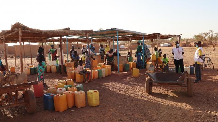 Des femmes et des enfants remplissent leurs jerricans avec de l'eau propre, dans un puits réhabilité de la ville de Titao. Février 2021. Burkina Faso. 
 © Noelie Sawadogo/MSF