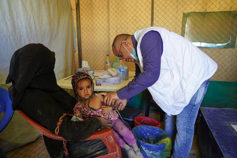 Un infirmier MSF prend le périmètre brachial d'une enfant qui souffre de malnutrition, dans la clinique mobile du camp de déplacés d'Al-Sweida à Marib. Yémen. 2021.
 © Hesham Al Hilali