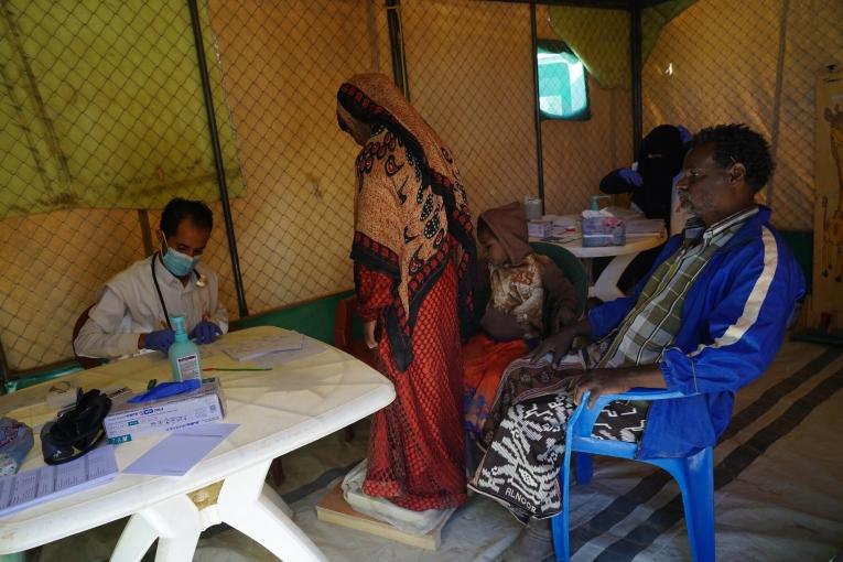 Abdu Sabit avec deux de ses filles lors d'une consultation dans la clinique mobile MSF du camp d'Al-Khuseif à Marib. Yémen. 2021.
 © Hesham Al Hilali