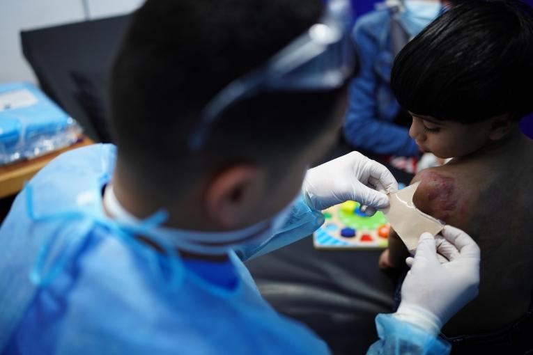 Un physiothérapeute MSF prépare un pansement additionnel pour Wadi, 3 ans. Gaza. 2021.
 © Tetiana Gaviuk/MSF