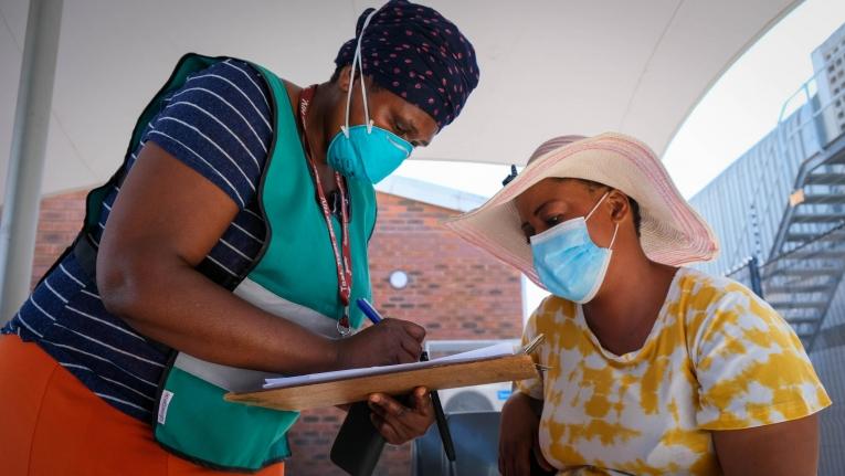 Une membre des équipes de promotion de la santé MSF aide une patiente à s'enregistrer pour la vaccination Covid-19 dans une clinique de Khayelitsha. Afrique du Sud.
 
 © MSF