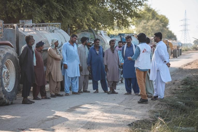 Un logisticien MSF discute avec l'équipe chargée de conduire les camions citernes à Dadu. Pakistan. 2022.
 
 © Zahra Shoukat/MSF