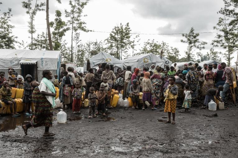 Des personnes déplacées du camp de Rusayo attendent pour collecter de l'eau. Nord-Kivu, République démocratique du Congo, avril 2023.
© Michel Lunanga
