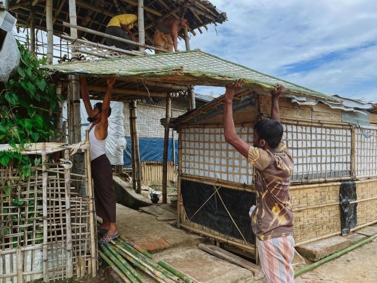Un groupe de personnes transportant des matériaux de construction dans les camps. 
 © Victor Caringal/MSF