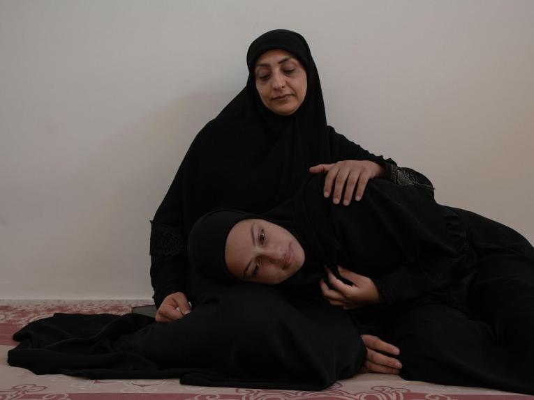 Ezdihar al Diqa, 39 ans, et sa fille Nouraya, 14 ans, dans la chambre qu'elles partagent avec 14 personnes dans le camp de personnes déplacées d'Azarieh, au centre de Beyrouth.
L'abri d'Azarieh, autrefois un centre commercial animé au cœur de la capitale libanaise, a été transformé en refuge pour les personnes déplacées par les bombardements israéliens au Liban. 
Octobre 2024. Liban. © Antoni Lallican/Hans Lucas