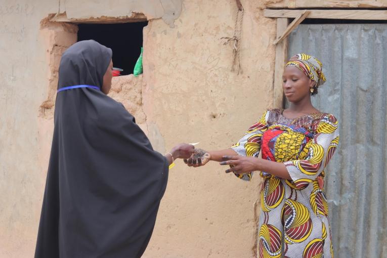 Une femme reçoit un bon pour récupérer une aide alimentaire de MSF afin de prévenir le risque de malnutrition chez ses enfants. Entre juillet et septembre, MSF a organisé quatre distributions pour plus de 70&nbsp;000 enfants.
 © Elkanah Yakubu