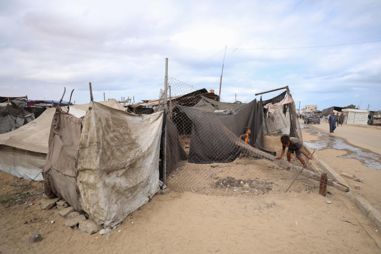 Des enfants jouent sur un enchevêtrement de câbles tombés dans une rue à côté de la tente où leur famille a trouvé refuge à Mawasi, Khan Younès. En raison du manque d'aires de jeux sécurisées, les enfants des camps de déplacés sont souvent exposés à des environnements dangereux et à des débris. Gaza, octobre 2025
 © Motasem Abu Aser/MSF