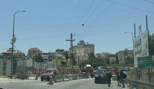 Des personnes attendent devant une barrière israélienne qui bloque l'accès à une route principale menant à Hébron. Beaucoup vont finir par passer à pied, malgré les risques. Ceux qui ont besoin de soins médicaux ou qui ne peuvent pas marcher sont restés bloqués, dans l'impossibilité de traverser. Cisjordanie, 14 juin 2025
