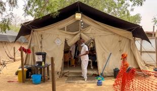 Un membre du personnel de MSF se tient devant une tente d'isolement pédiatrique, où les enfants atteints de rougeole reçoivent des soins intensifs. Hôpital d'Adré, province de Ouaddaï, Tchad.