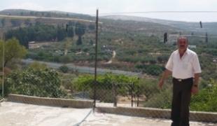 Naplouse  Juillet 2009 : du toit de sa maison ce patient nous montre le mur d'enceinte (bleu) de la colonie voisine.