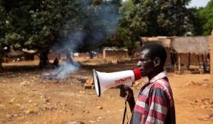 Un travailleur communautaire MSF annonce l'heure et le lieu d'une vaccination. République centrafricaine. 2020.