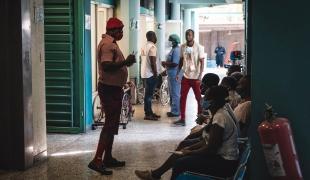 Un membre du personnel soignant parle aux patients dans la zone de triage du centre d'urgence MSF de Turgeau.