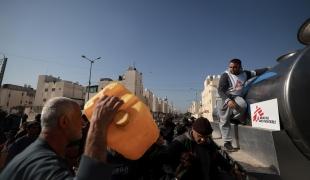 Youssef Al-Khishawi, an MSF water and sanitation agent, oversees a water distribution for displaced people in the southern Gaza town of Rafah’s Saudi neighborhood.