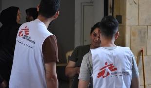 Des membres des équipes MSF en discussion avec une personne déplacée installée dans le refuge d'Azarieh à Beyrouth, lors d'une clinique mobile. Octobre 2024. Liban. 