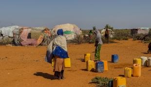  Au point de distribution d'eau du camp de déplacés de Rasqabobe, dans la région de Mudug, en Somalie, les habitants remplissent des jerrycans.