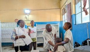 Un médecin et l'équipe de MSF  examinent un enfant de trois ans hospitalisé depuis deux jours pour une rougeole dans un hôpital du Sud Ubangi