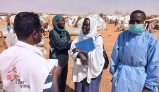 Un membre du personnel de MSF discute avec une femme à Al Mina Al Muwahad, le plus grand camp de déplacés près de la ville d'El Obeid.