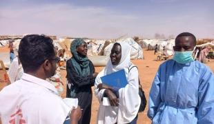 Un membre du personnel de MSF discute avec une femme à Al Mina Al Muwahad, le plus grand camp de déplacés près de la ville d'El Obeid.