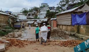 Des personnes marchant le long d'une route principale dans les camps. 